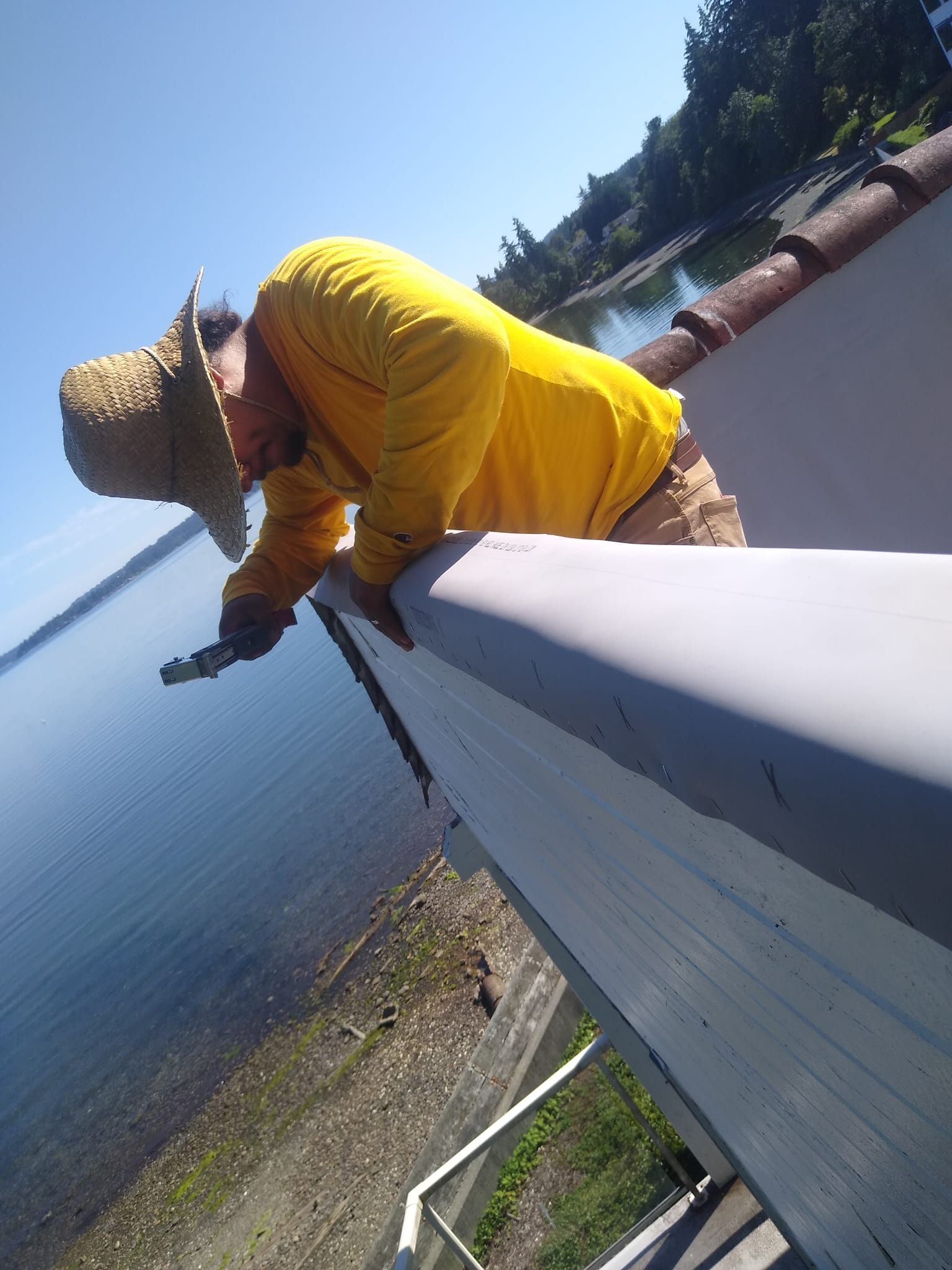 A skilled Roofer is shown fixing a TPO roofing system on a parapet wall, ensuring top-notch repair and maintenance services for commercial roofs Prevent and Deal with Roof Leaks in Washington's Rainy Season. Tips for Homes in High-Wind Areas