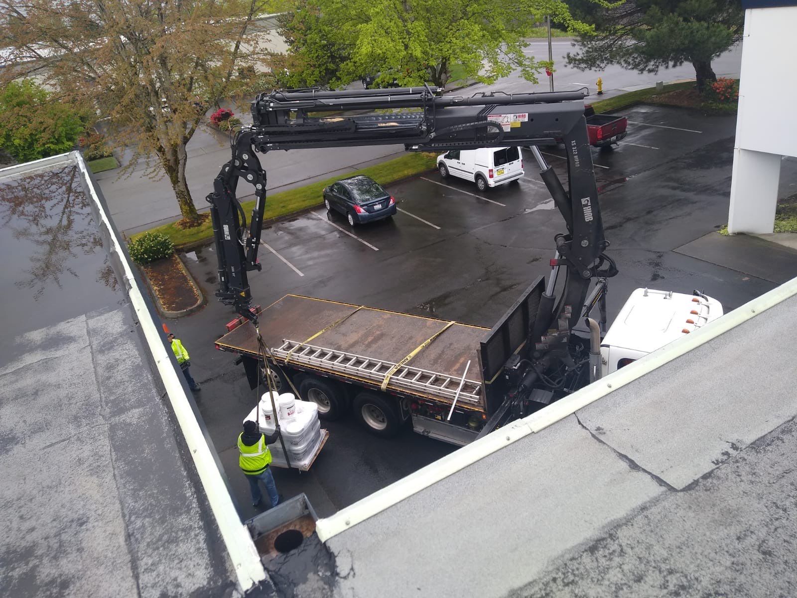 Boom truck hauling materials to roof.