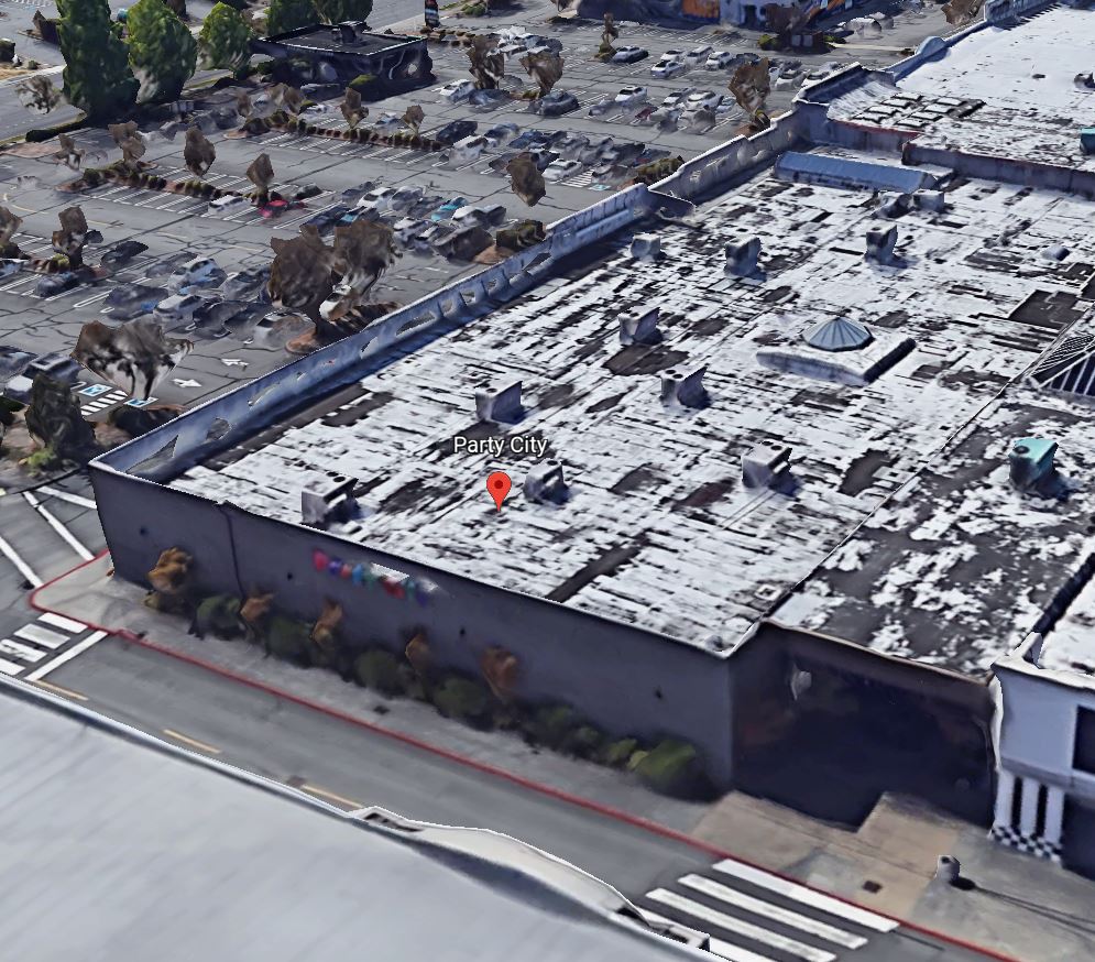 Commercial roofing construction with workers on top of a flat roof.